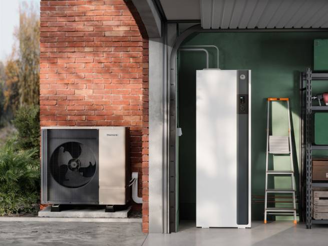 Pompe à chaleur extérieure à côté d'un bâtiment en brique.