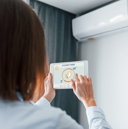 Personne contrôlant climatisation avec une tablette.